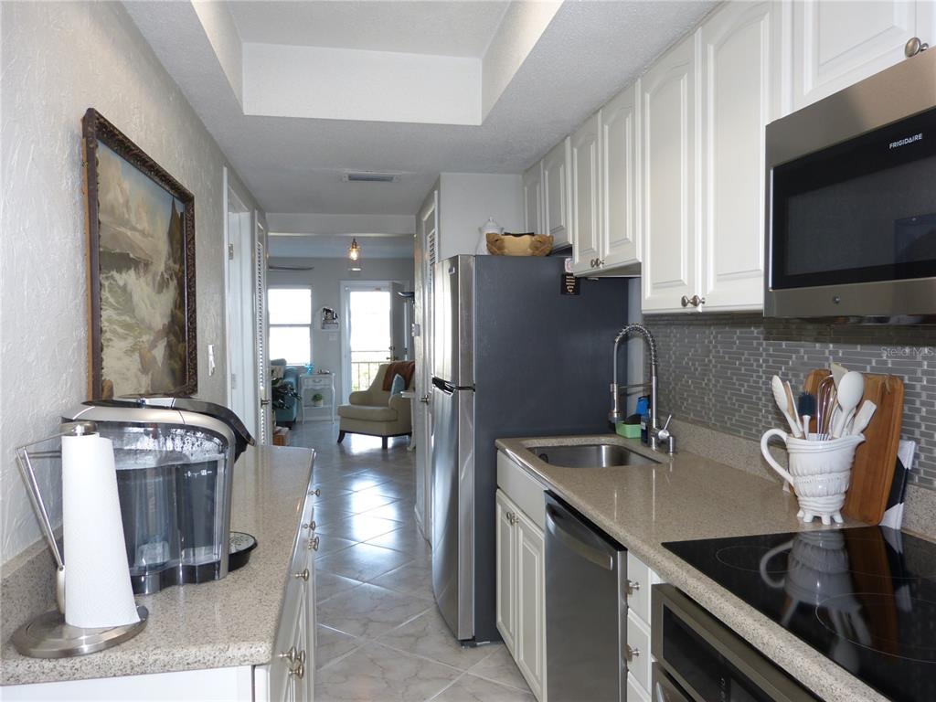 2 Causeway Boulevard, Unit 206 Dunedin, FL 34698 - Photo 14 of 26 a kitchen with table and chairs