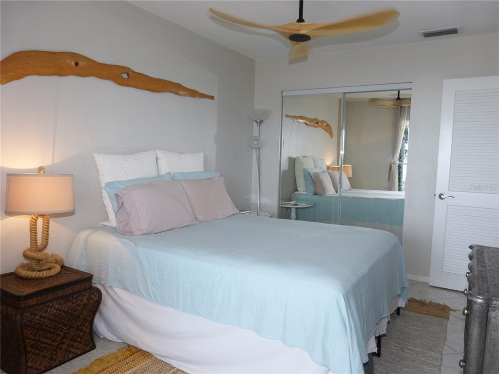 2 Causeway Boulevard, Unit 206 Dunedin, FL 34698 - Photo 18 of 26 a bedroom with a bed and a lamp