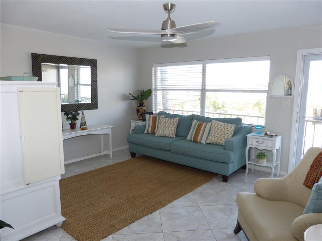 2 Causeway Boulevard, Unit 206 Dunedin, FL 34698 - Photo 6 of 26 a living room with furniture and a large window