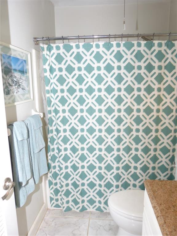 2 Causeway Boulevard, Unit 206 Dunedin, FL 34698 - Photo 9 of 26 a bathroom with a granite countertop sink and a toilet