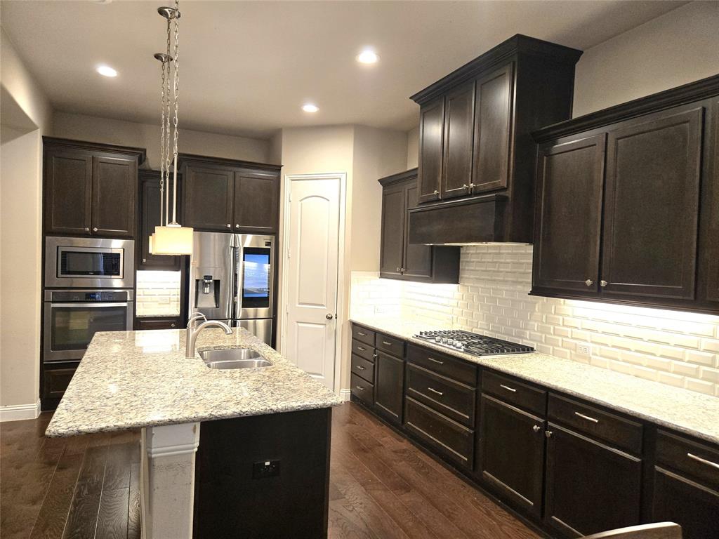 680 Wingate Road Coppell, TX 75019 - Photo 12 of 23 a kitchen with stainless steel appliances kitchen island granite countertop a sink refrigerator and cabinets
