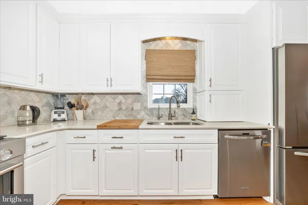 a kitchen with granite countertop white cabinets and white appliances
