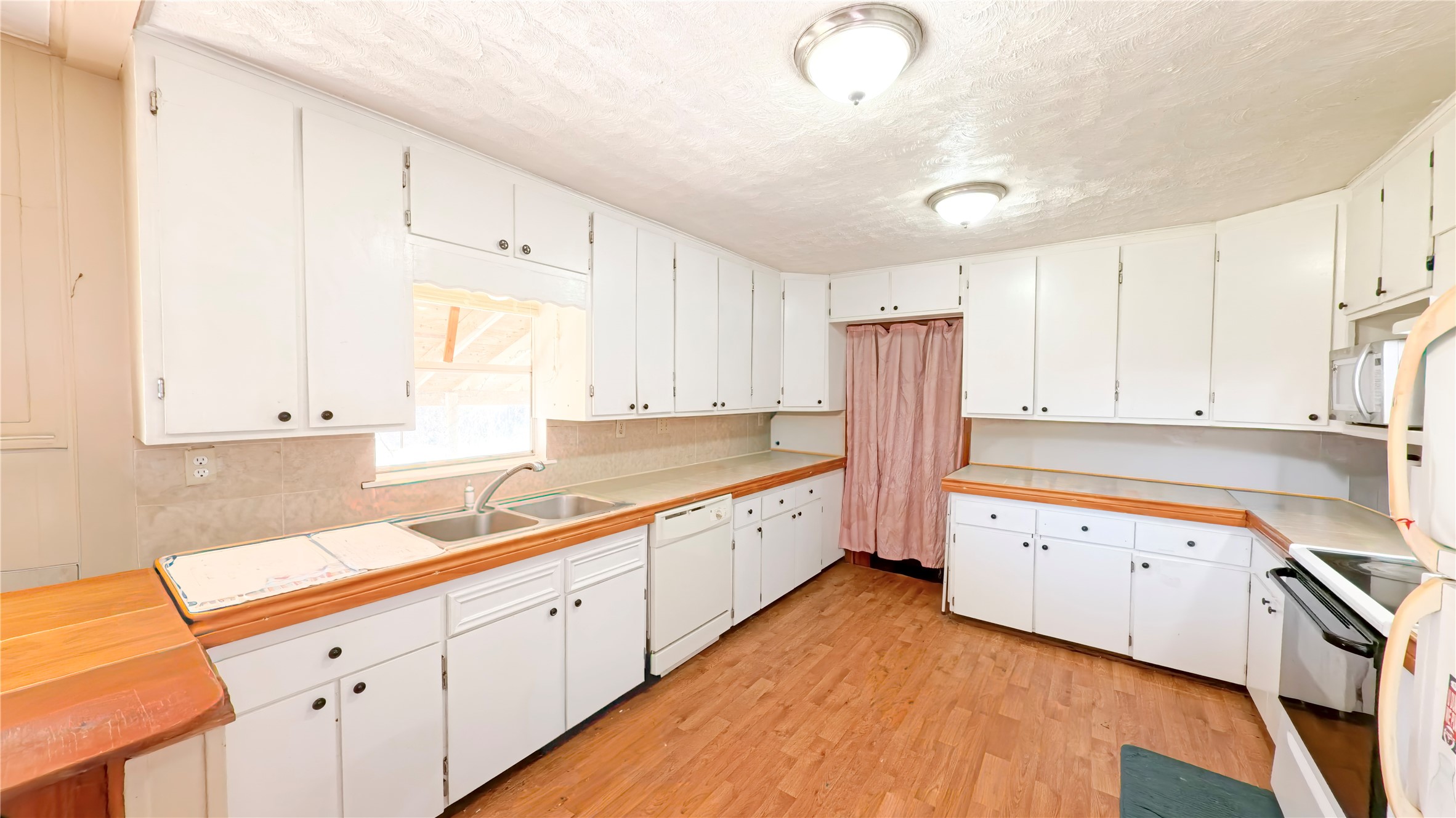 14452 Half Circle Splendora, TX 77372 - Photo 8 of 13 a large white kitchen with stainless steel appliances granite countertop a stove a sink dishwasher and white cabinets with wooden floor