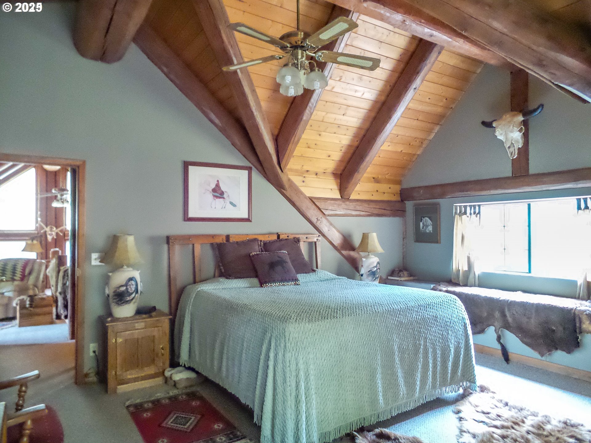 1138 Yokum Road Riddle, OR 97469 - Photo 13 of 33 a bedroom with a large bed and a chandelier