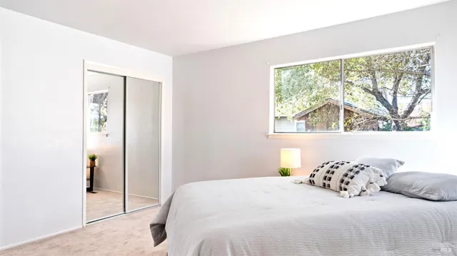 a bedroom with a large bed and a large window