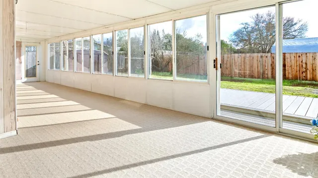 a view of an empty room with wooden floor and a porch