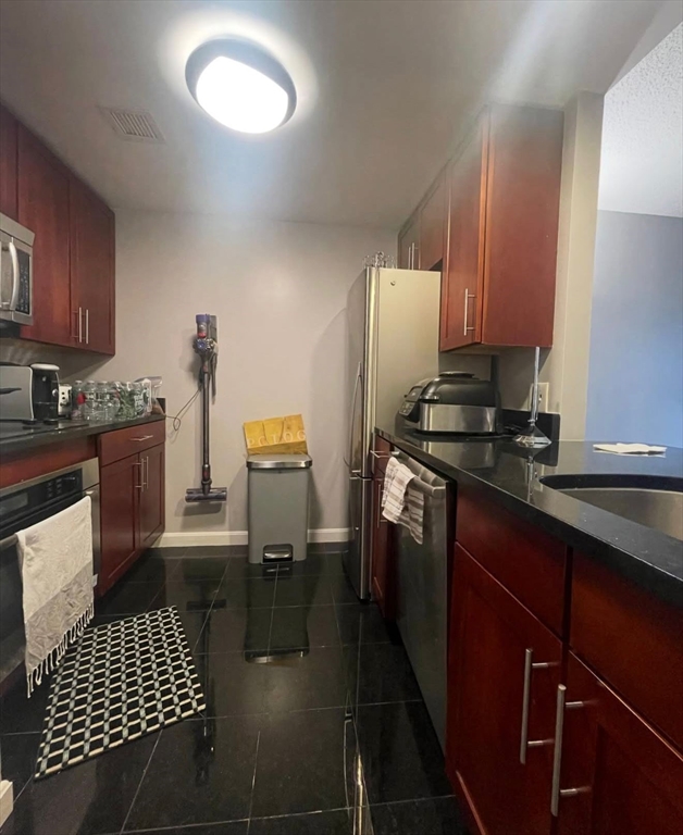 10 Museum Way, Unit 528 Cambridge, MA 02141 - Photo 6 of 10 a kitchen with stainless steel appliances a sink stove and cabinets
