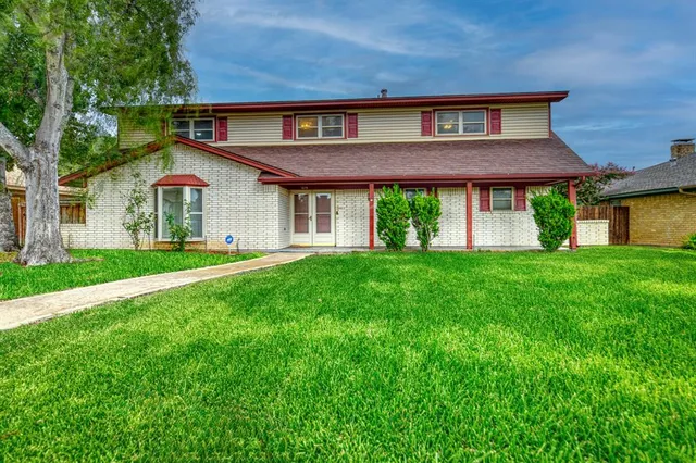 a front view of a house with a yard and trees