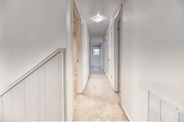 a view of a hallway with wooden floor and entryway