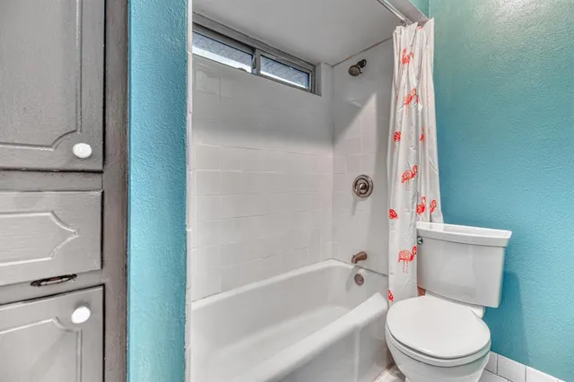 a white toilet sitting next to a bath tub and shower