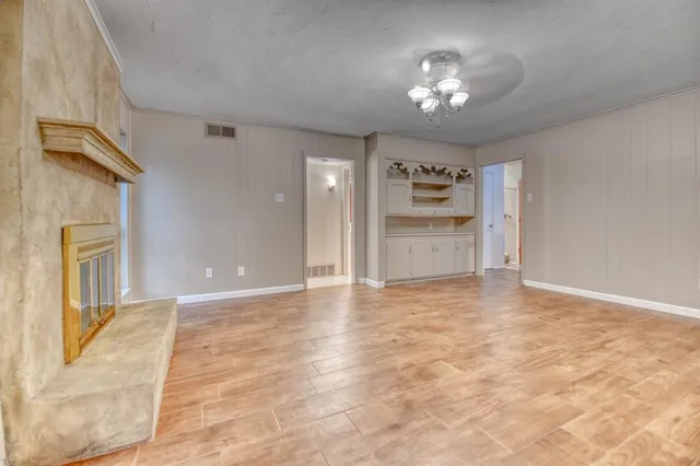 a view of an empty room and a kitchen