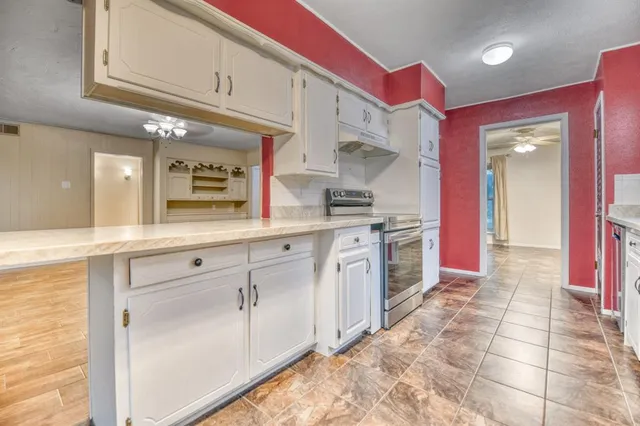 a kitchen with stainless steel appliances kitchen island granite countertop a stove a sink and a microwave