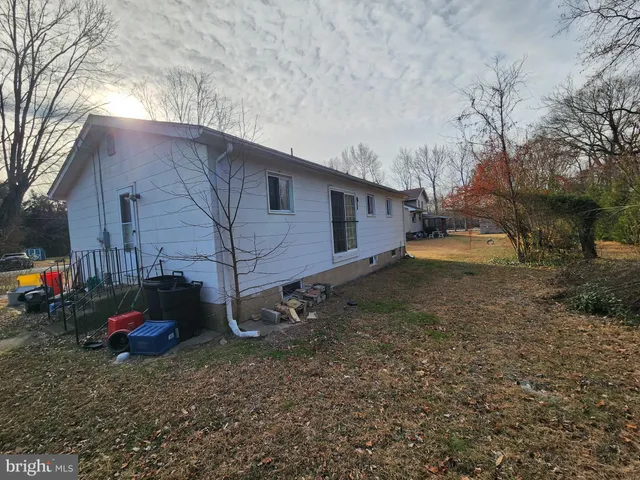 a backyard of a house with barbeque oven and a table and chairs