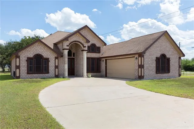 a front view of a house with a garden and entryway