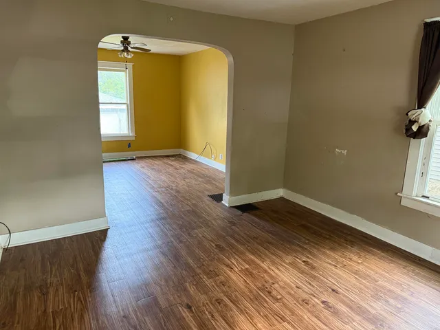 an empty room with wooden floor and a window