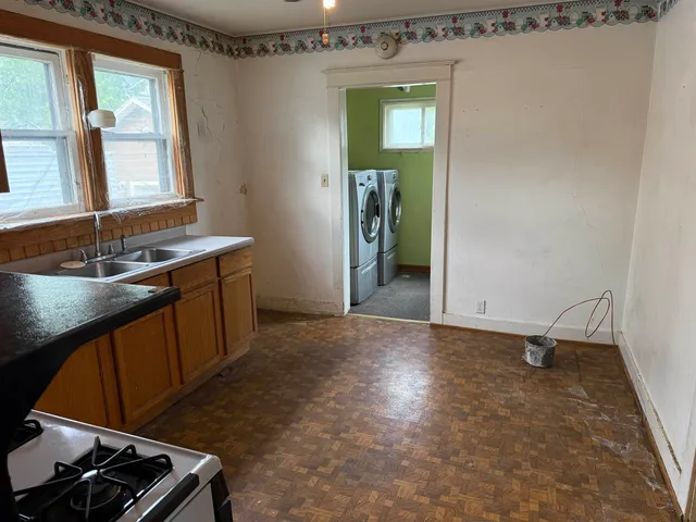 a kitchen with granite countertop a sink a stove and cabinets
