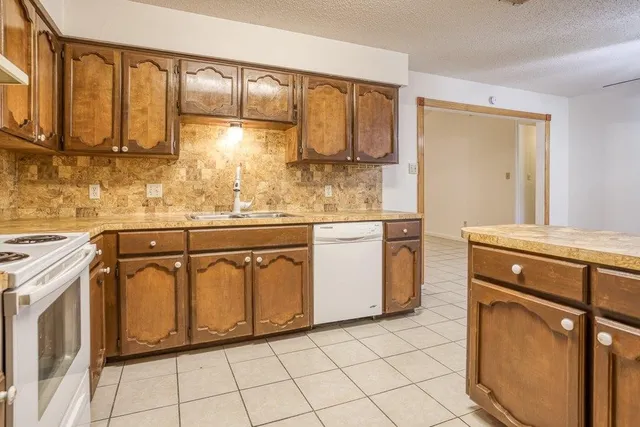 a kitchen with stainless steel appliances granite countertop a sink and cabinets with wooden floor