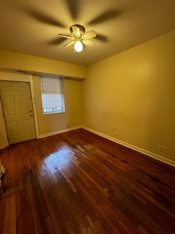 a view of a room with wooden floor and fan