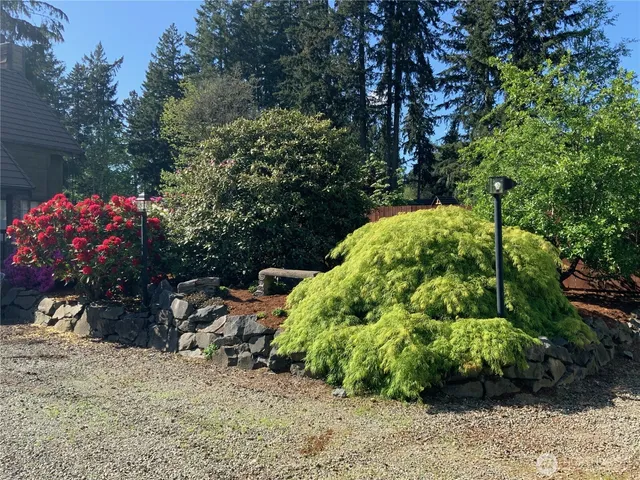a backyard of a house with lots of green space and fountain