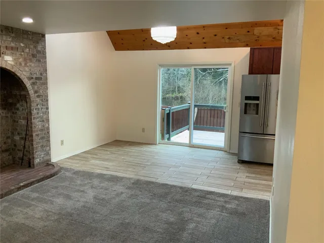 an empty room with large windows and a fireplace
