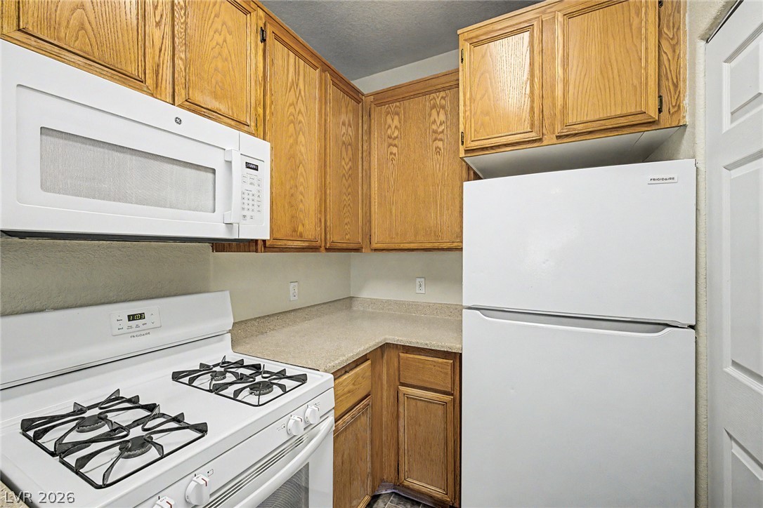 4730 East Craig Road, Unit 1091 Las Vegas, NV 89115 - Photo 13 of 23 Functional workspace with abundant oak cabinetry and laminate countertops.