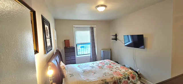 a bedroom with furniture and a flat screen tv