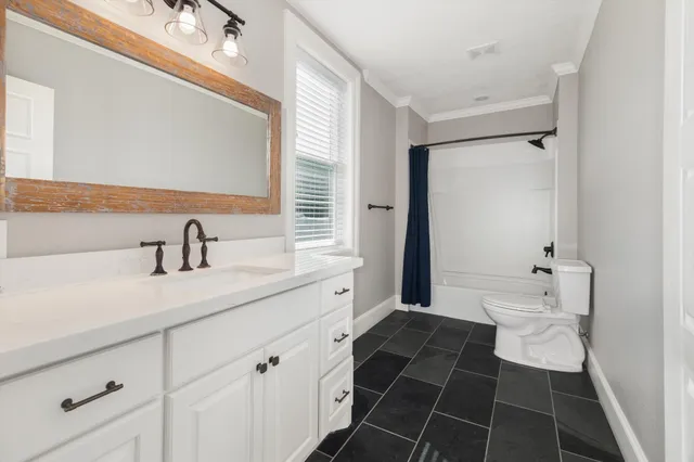 a white toilet sitting next to a bath tub