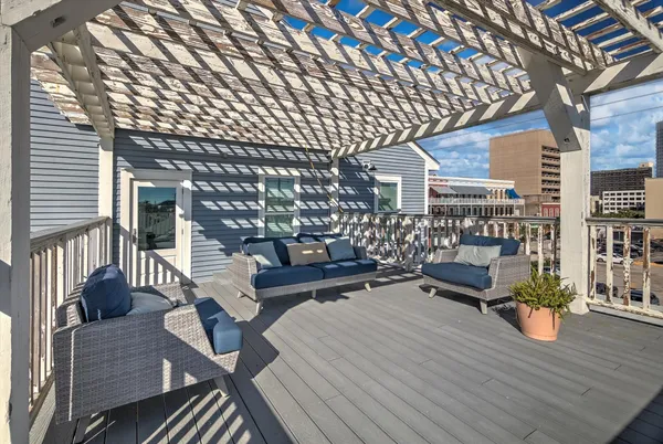a view of a house with wooden deck and furniture