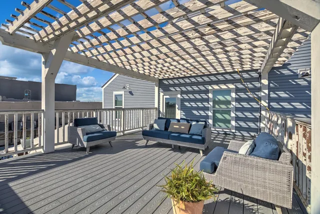 a view of a roof deck with couches and wooden floor