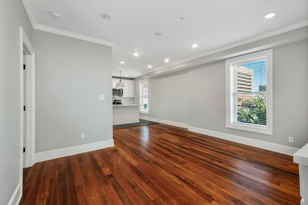 a kitchen that has a lot of white cabinets and stainless steel appliances