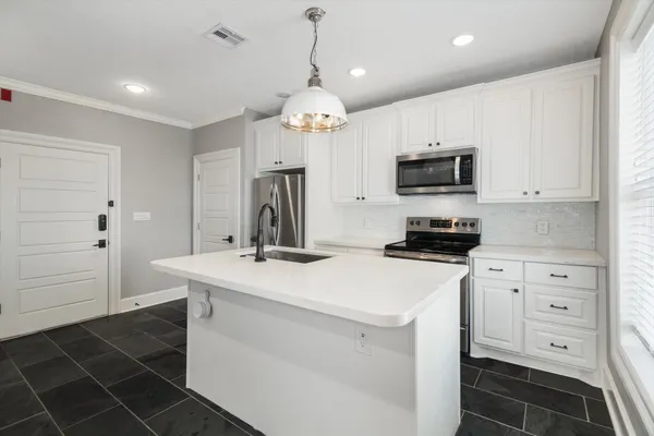 a kitchen with stainless steel appliances a refrigerator sink and cabinets