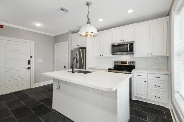 a kitchen with stainless steel appliances a refrigerator sink and cabinets