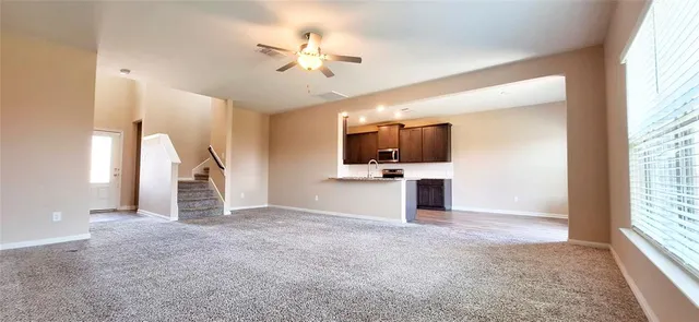 an empty room with windows and ceiling fan