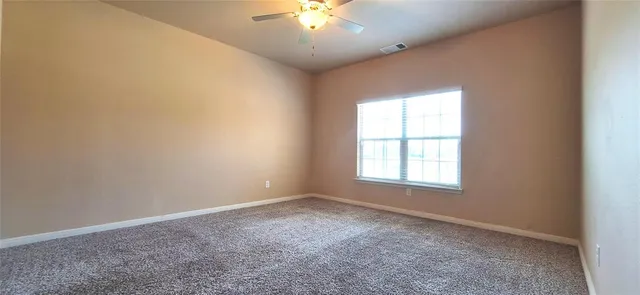 an empty room with a window and a chandelier fan