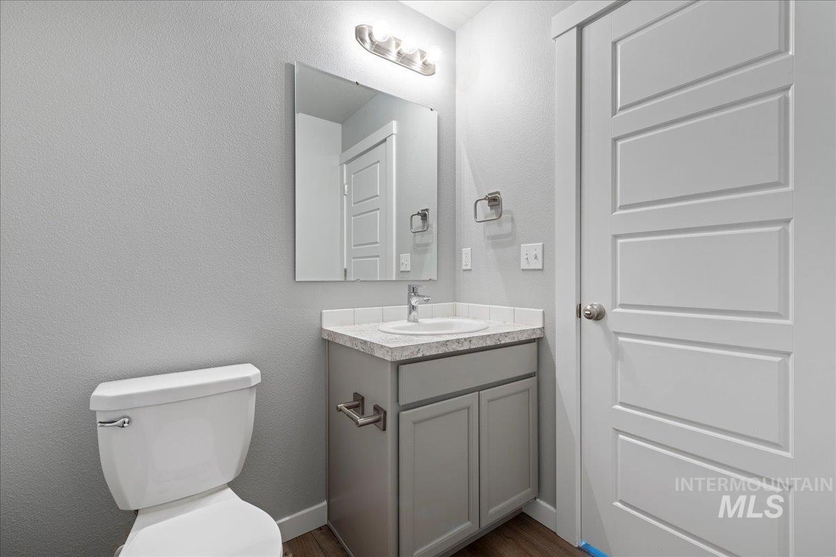2513 East Goldstone Street Meridian, ID 83642 - Photo 12 of 27 Bathroom with a textured wall, vanity, and dark wood finished floors