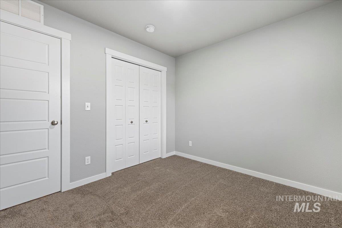 2513 East Goldstone Street Meridian, ID 83642 - Photo 14 of 27 Unfurnished bedroom with dark carpet and a closet