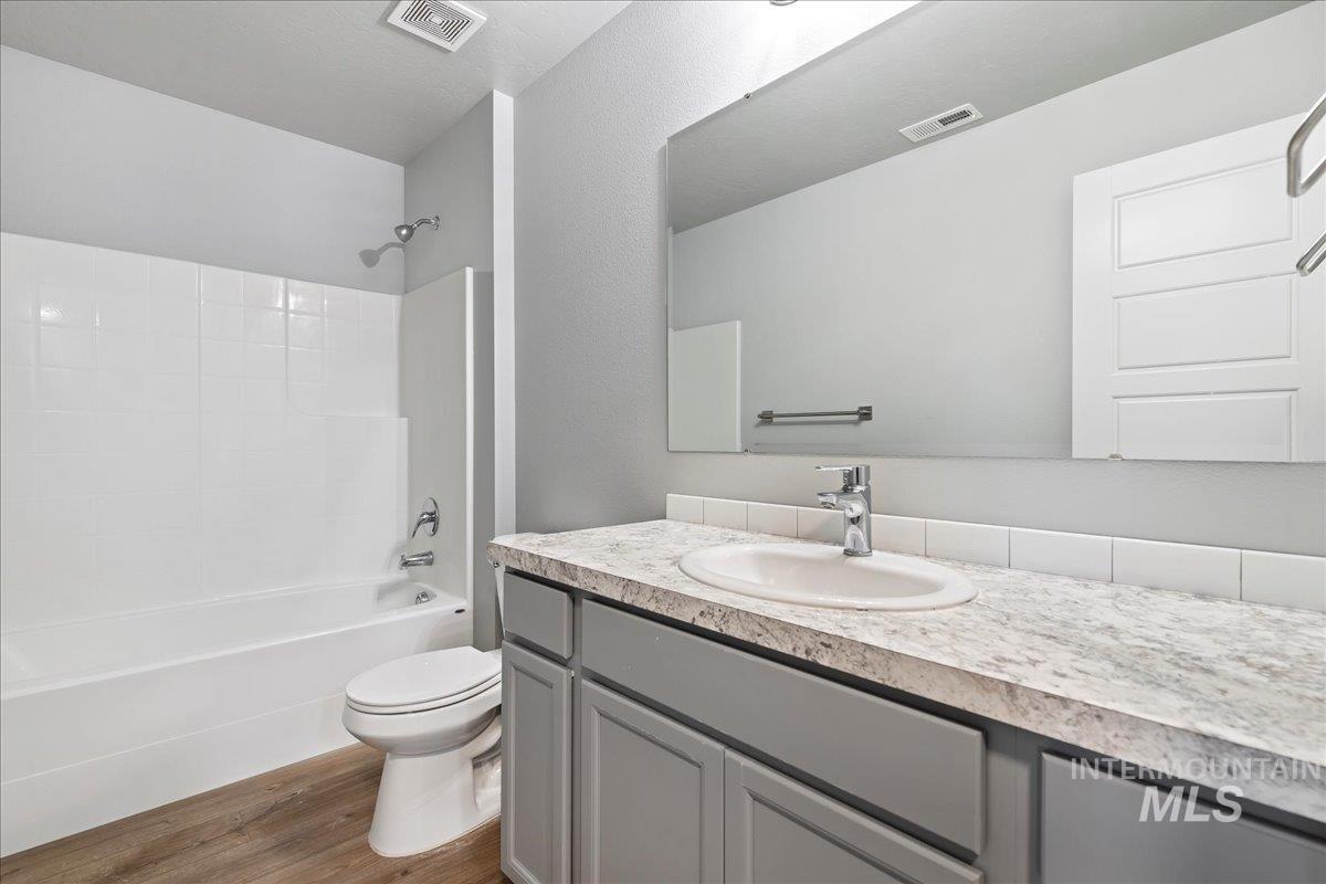 2513 East Goldstone Street Meridian, ID 83642 - Photo 17 of 27 Bathroom featuring vanity, shower combination, and dark wood-style flooring