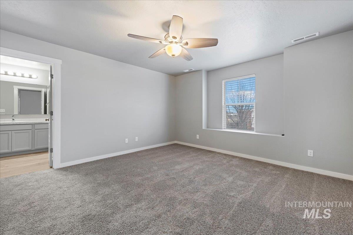 2513 East Goldstone Street Meridian, ID 83642 - Photo 19 of 27 Unfurnished bedroom featuring light carpet, ceiling fan, and ensuite bath