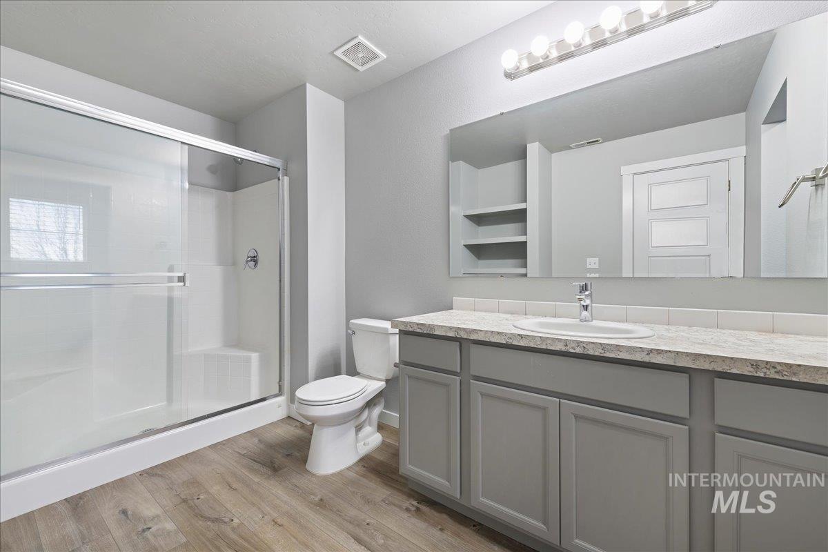 2513 East Goldstone Street Meridian, ID 83642 - Photo 21 of 27 Full bath featuring vanity, a stall shower, and light wood-style floors