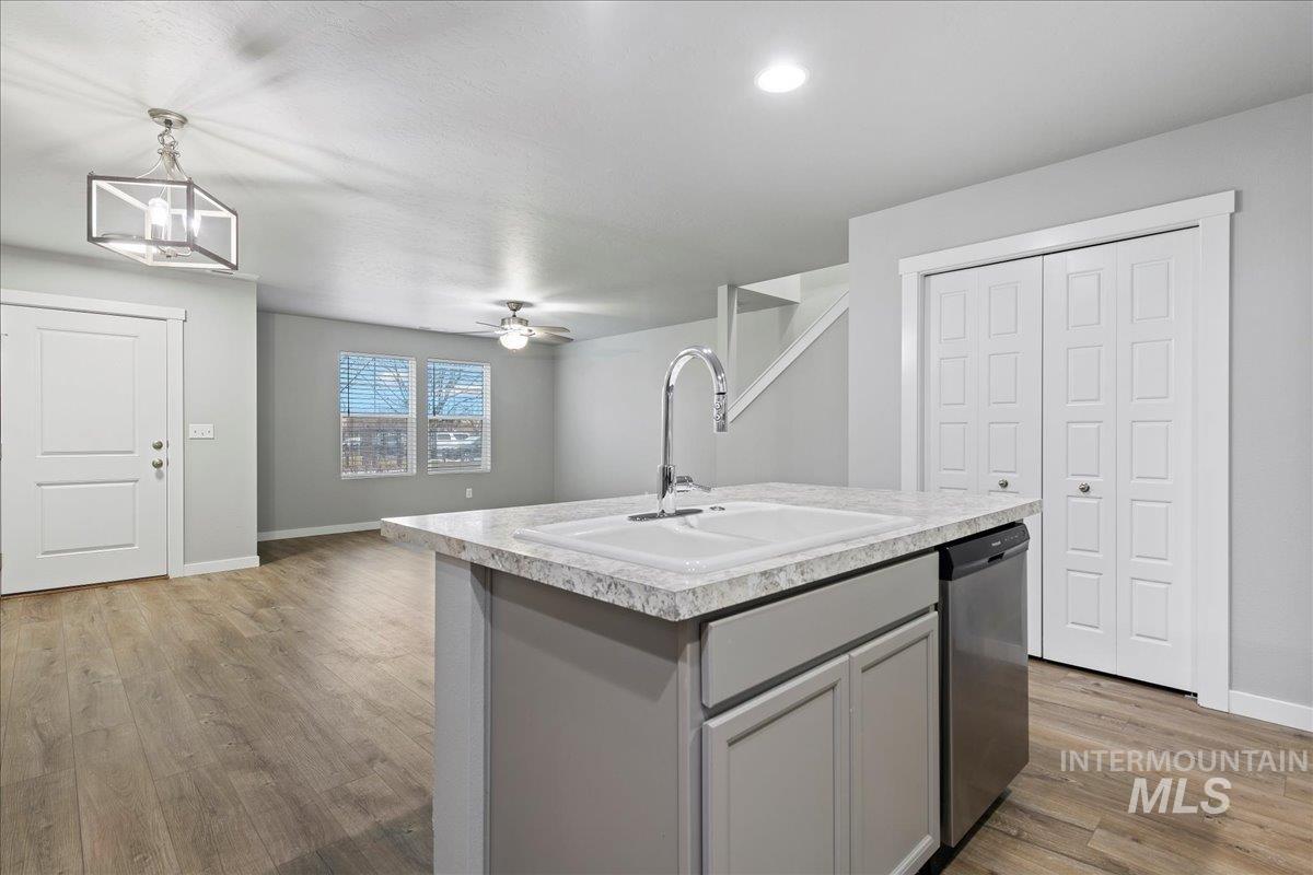 2513 East Goldstone Street Meridian, ID 83642 - Photo 10 of 27 Kitchen featuring light countertops, light wood-style floors, gray cabinets, a ceiling fan, and stainless steel dishwasher