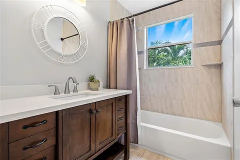 a bathroom with a bathtub a mirror a sink and a shower