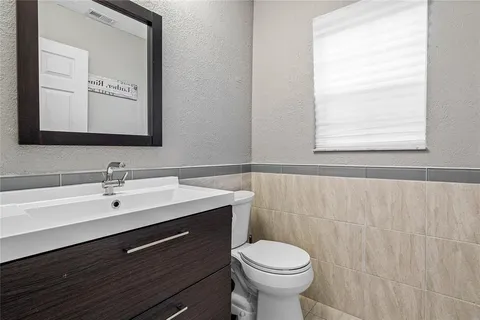 a bathroom with a sink mirror and toilet
