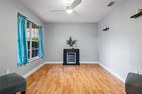 a view of empty room with wooden floor and fan