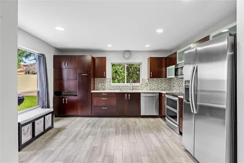 a kitchen with stainless steel appliances granite countertop a refrigerator and a stove top oven