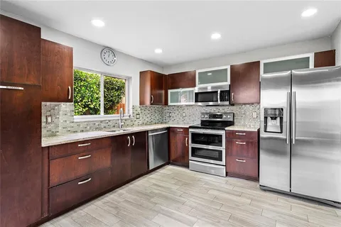 a kitchen with stainless steel appliances granite countertop a refrigerator and a sink