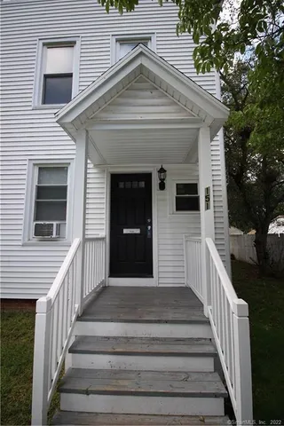a view of a house with wooden fence and a porch