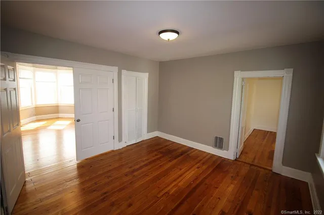 a view of empty room with wooden floor