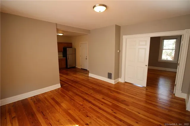 wooden floor in an empty room with a window