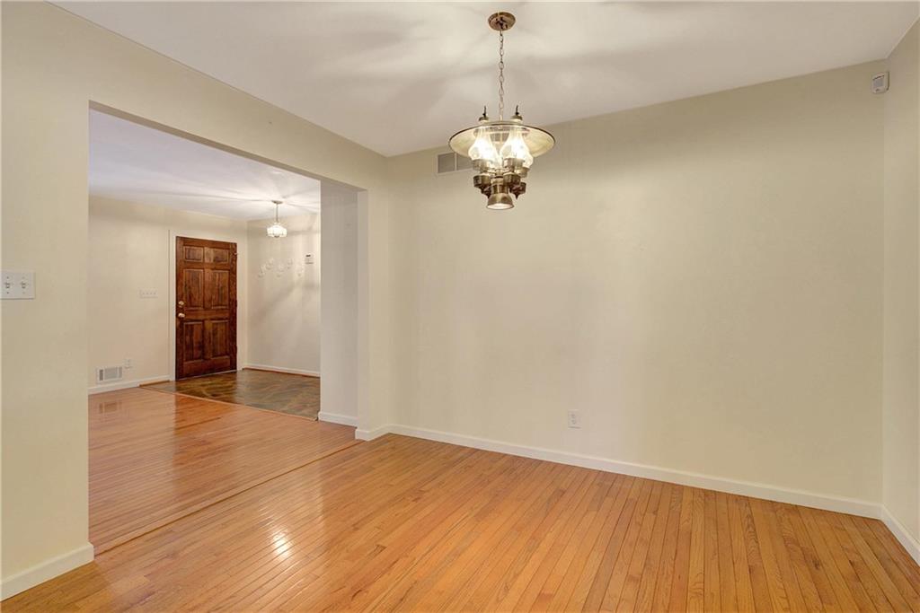 10185 Henry Mill Road Chattahoochee Hills, GA 30213 - Photo 18 of 41 a view of empty room with wooden floor and chandelier