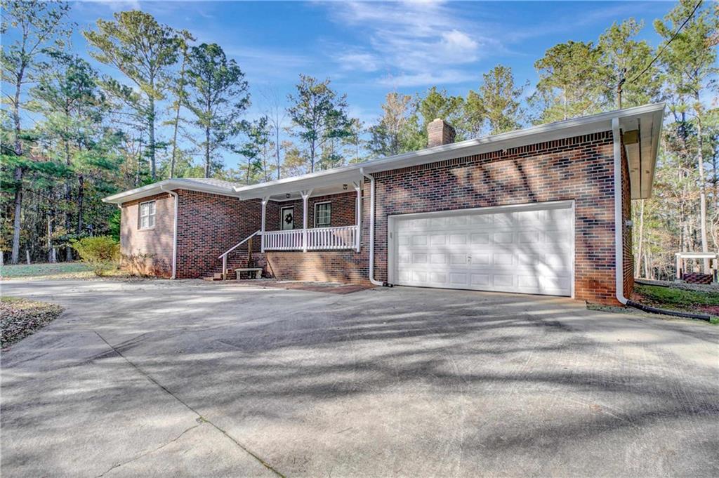 10185 Henry Mill Road Chattahoochee Hills, GA 30213 - Photo 35 of 41 a front view of a house with a yard and garage